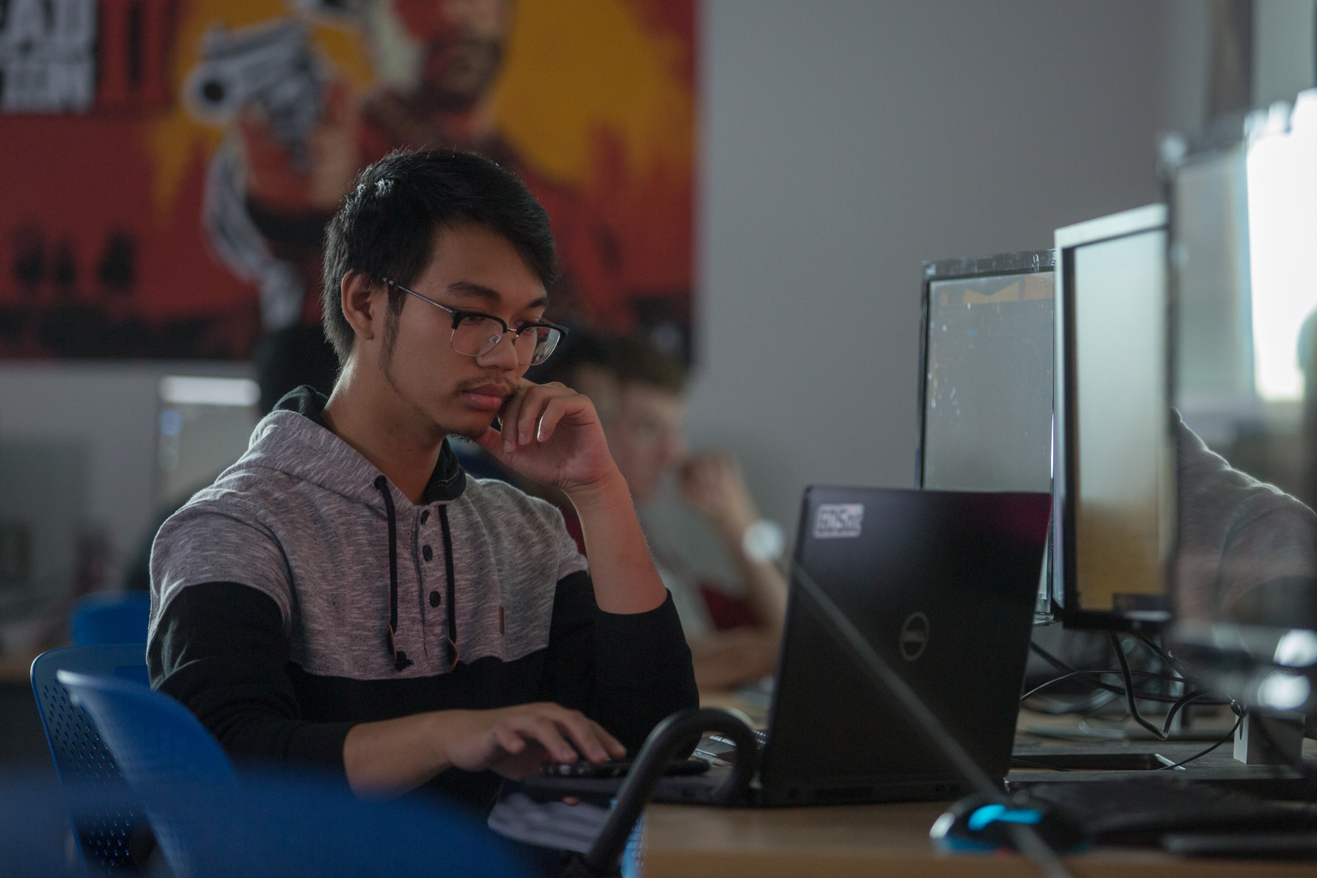 student looking at dual monitor screens with graphs