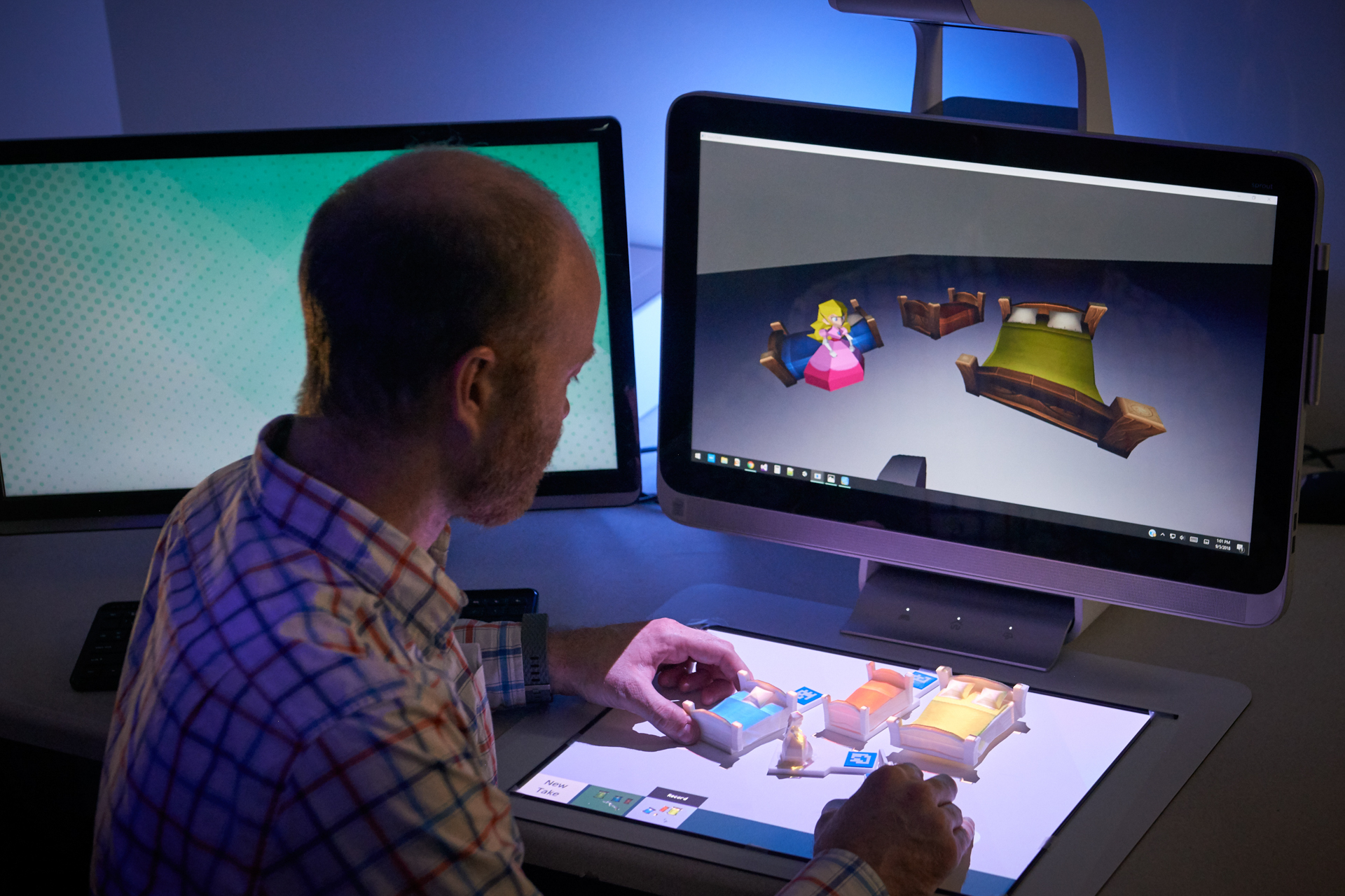 A student is working with 3D models that are also displayed on the computer screen in front of him