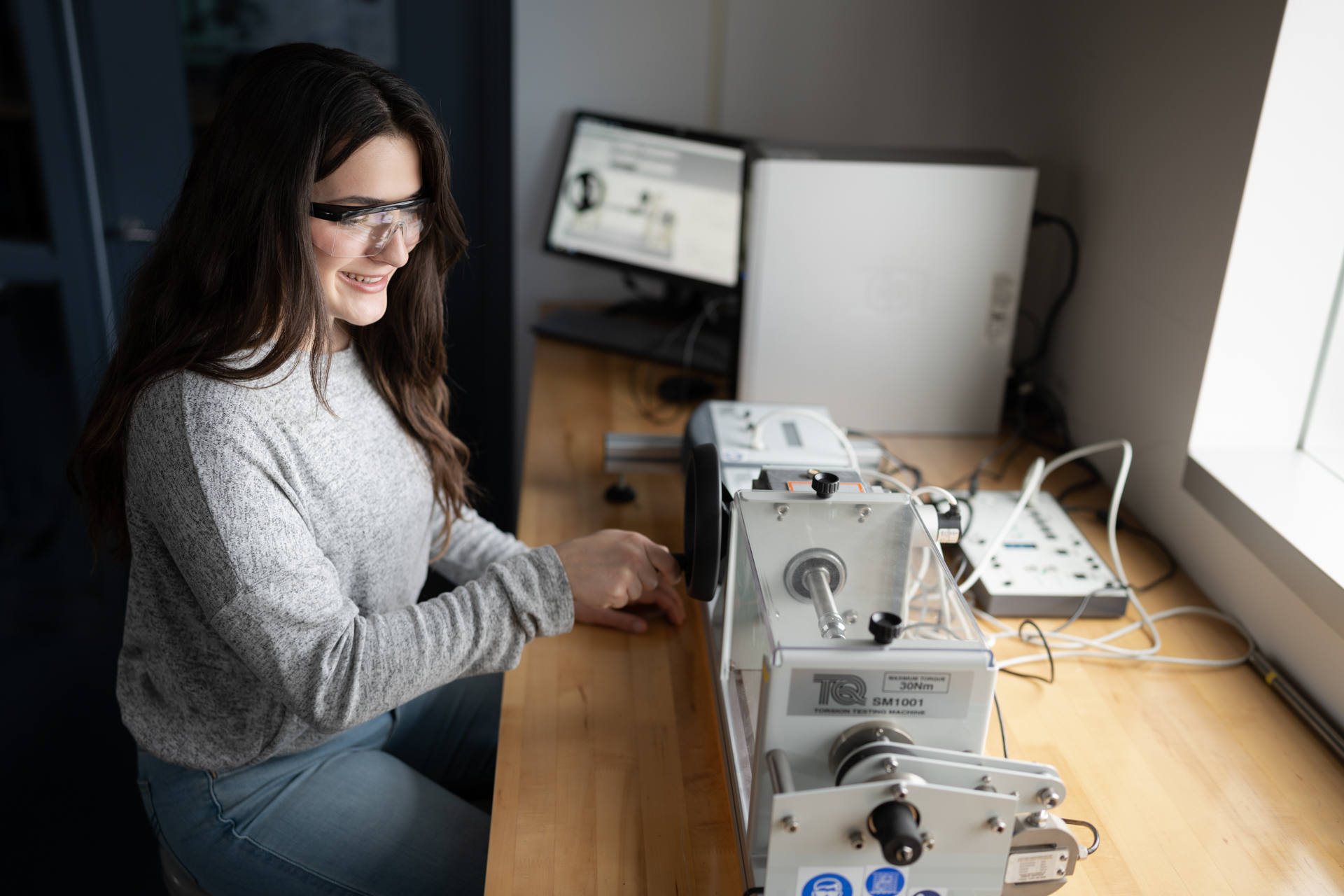 A student is working on engineering equipment.