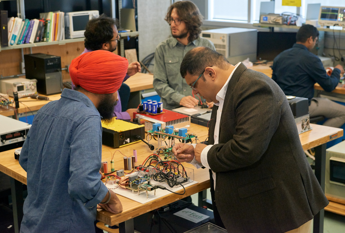 Students and professor working on computers. 