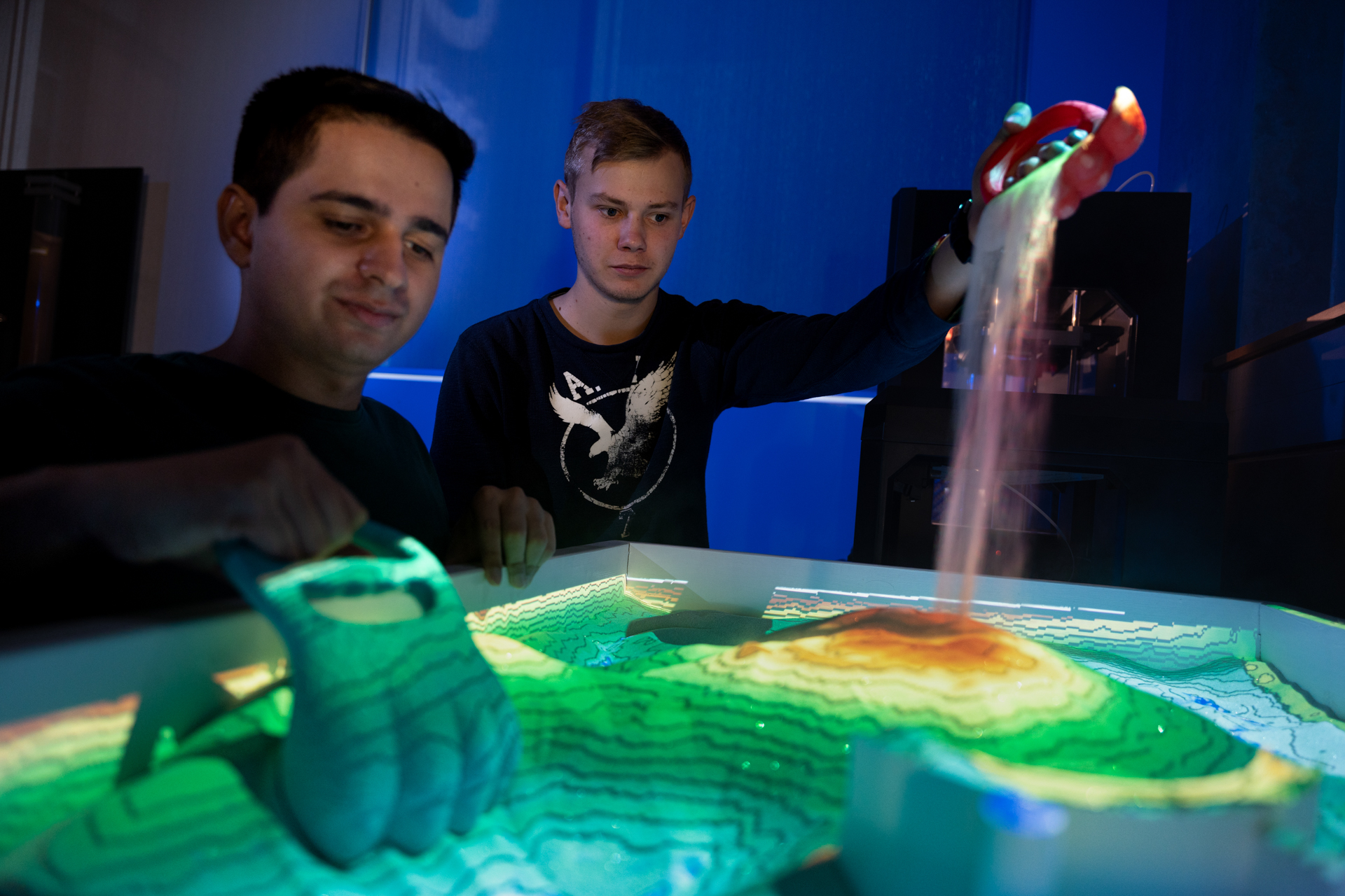 Two students are collaborating on nuclear energy equipment.