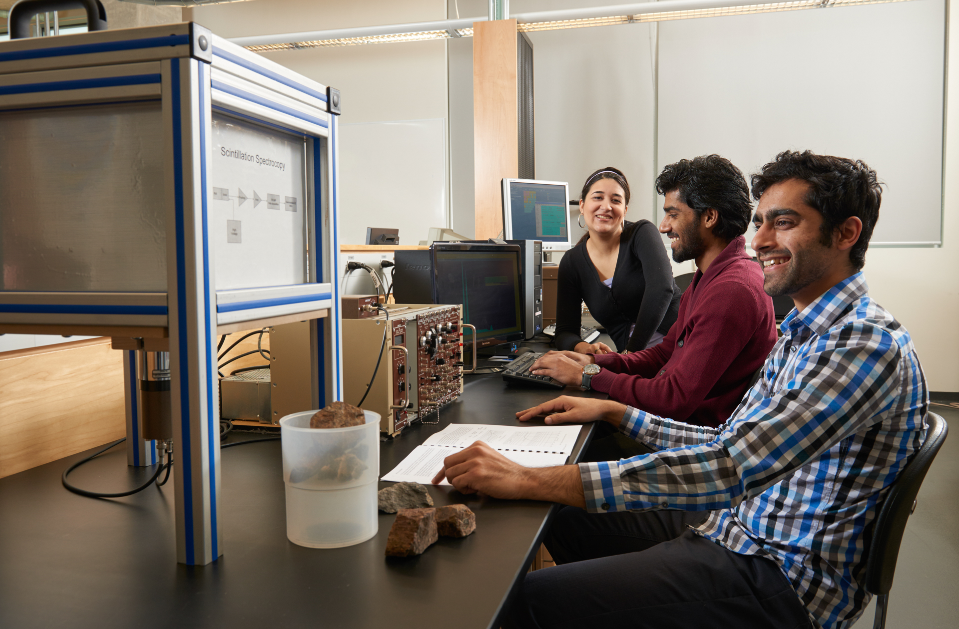 A student sits at a table analyzing engineering equipment.