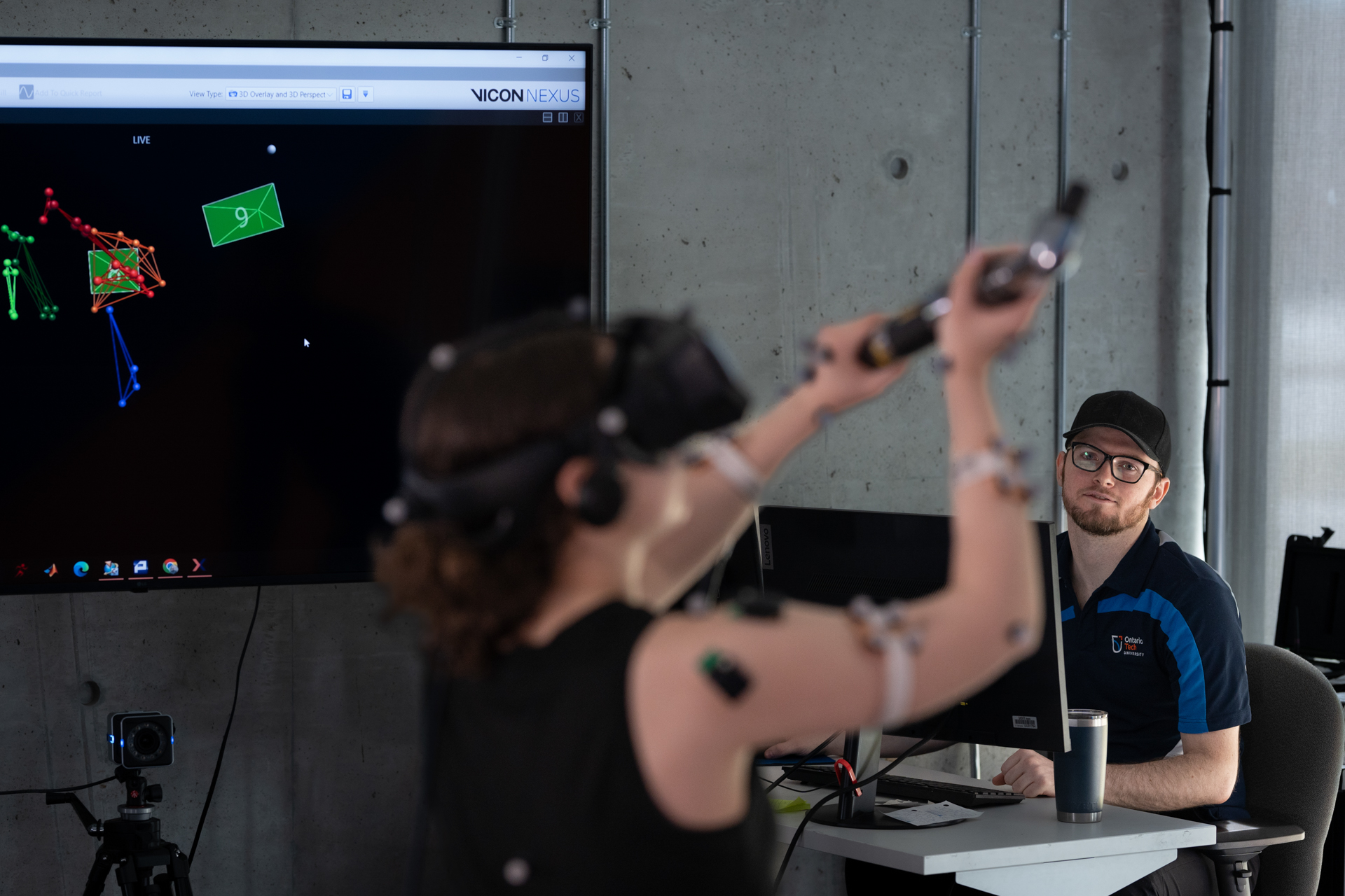 Two students are interacting with virtual reality equipment for kinesiology lab.