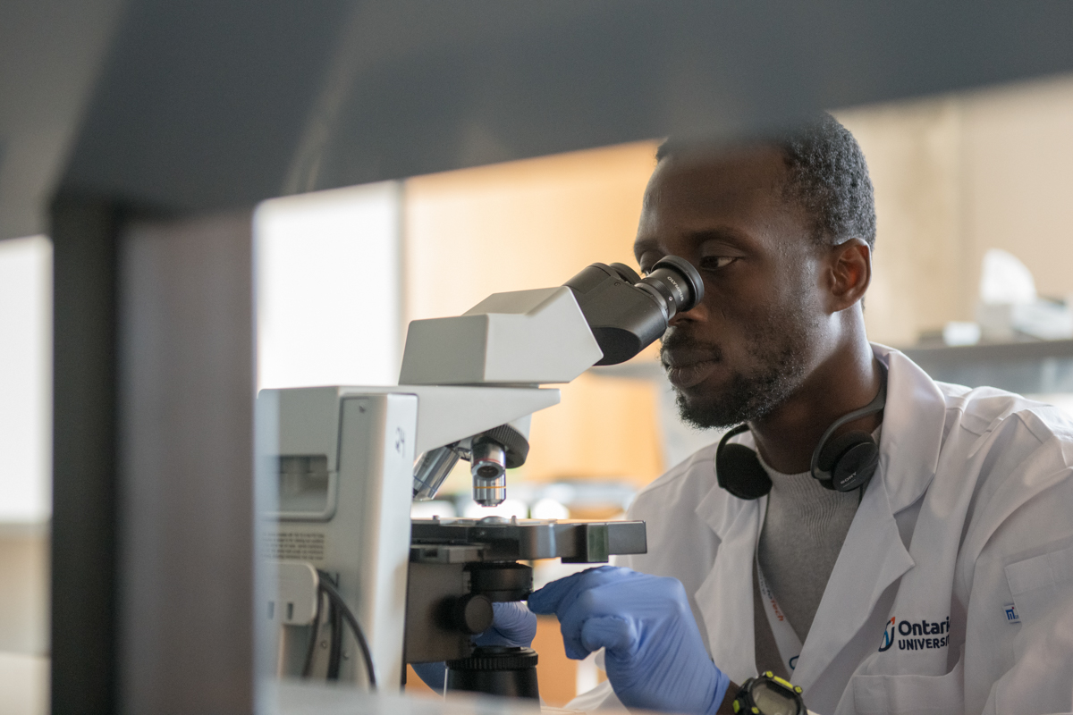 Student looking through a microscope.
