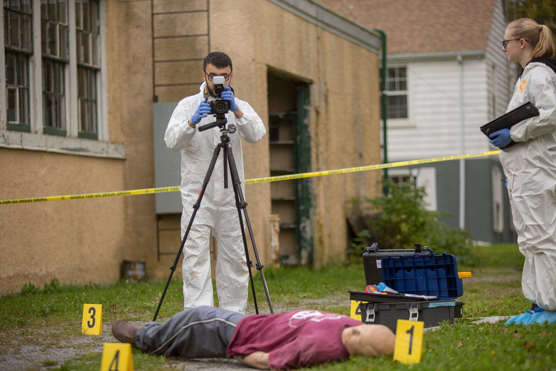 A student adjusts a camera while working on a crime scene lab.