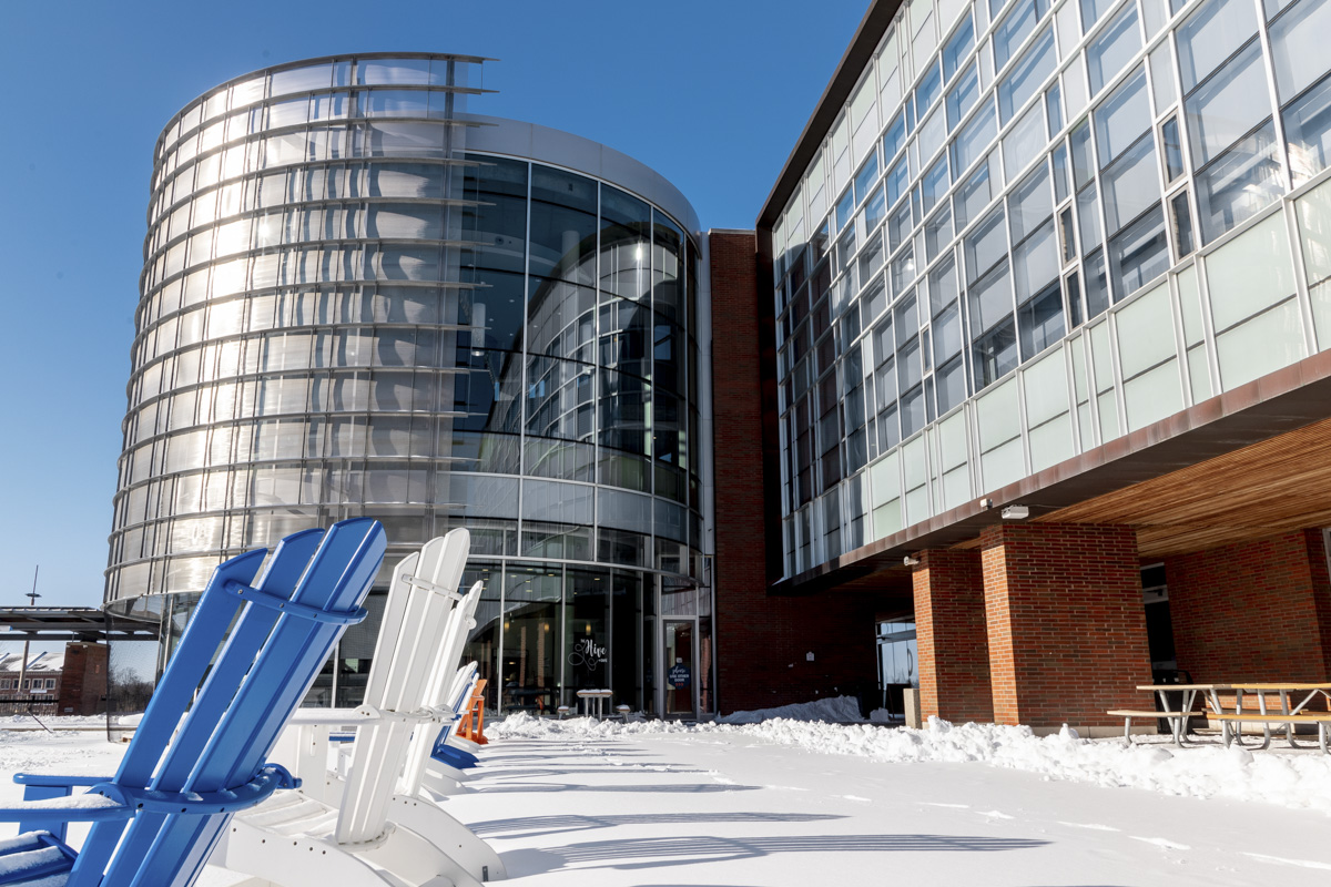 The Library building with snow on the ground, angled to capture the lounge chairs which are blue and white