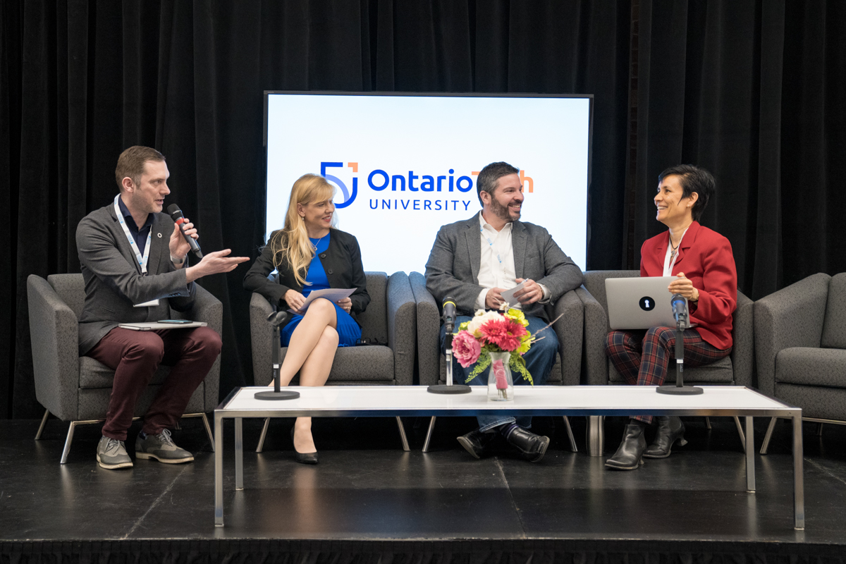 Four people are sitting on stage hosting a discussion.