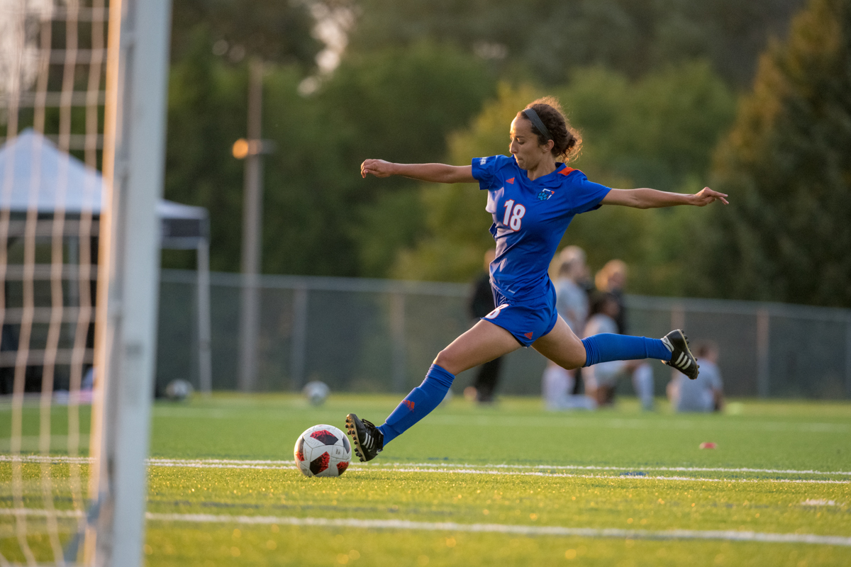 A member of the Ridgebacks Women's Soccer team kicks the ball on the field.