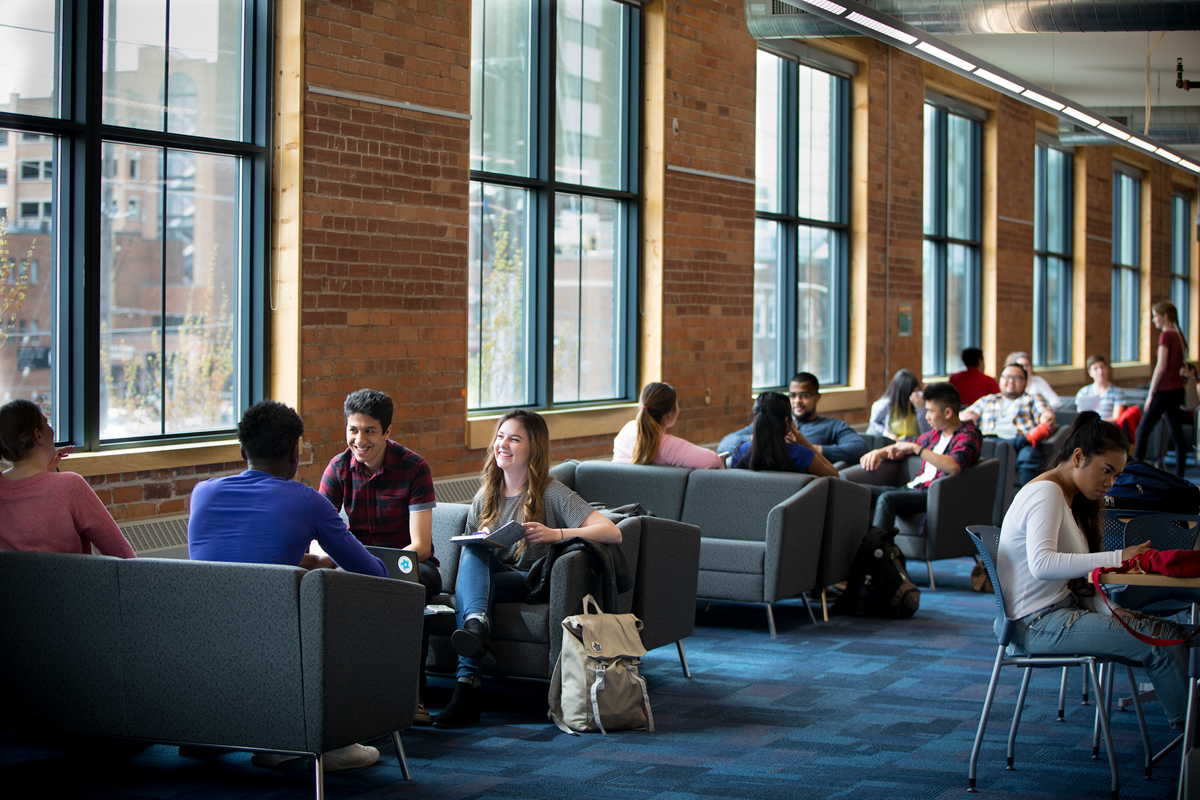 students sitting and talking on couches in 61charles campus.