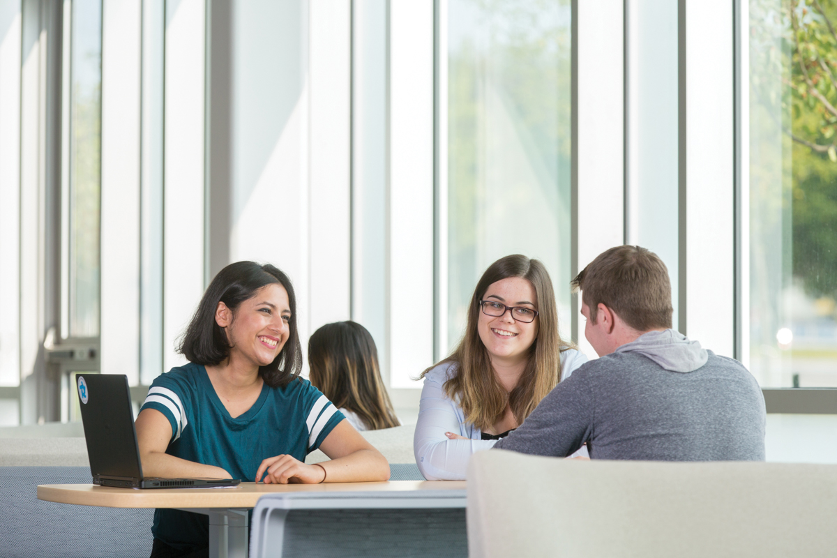 life on campus image showing chairs, common area, computer, glass, north campus, sitting, smiling, students, tables, talking at software and informatics research centre