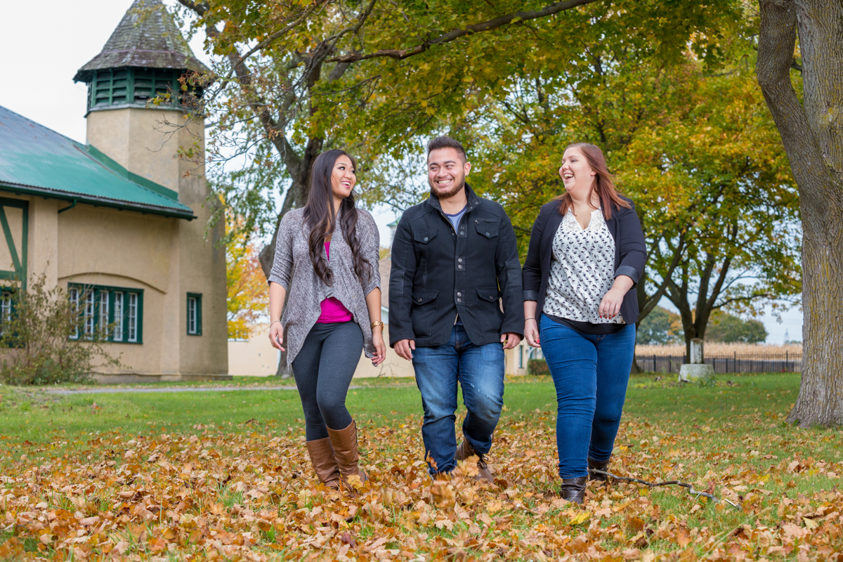 Students on campus with trees with fall coloured leaves in the background