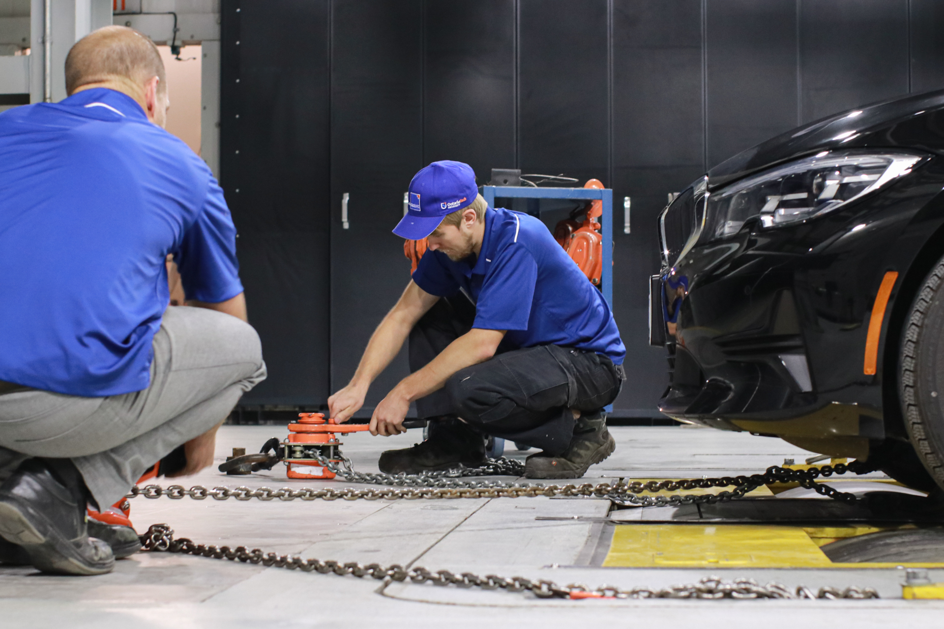 Two students are working on a vehicle.